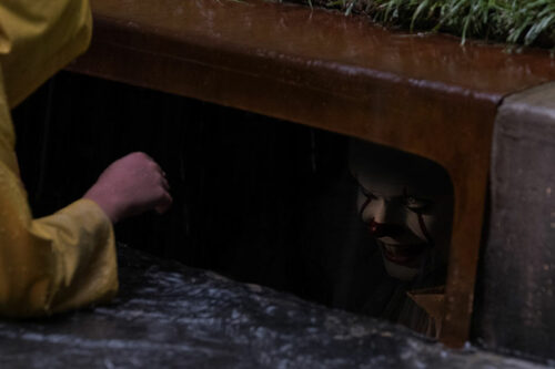 Splitscreen Review - Ça réalisé par Andy Muschietti - image du film, Georgie discute avec le clown caché dans les égouts